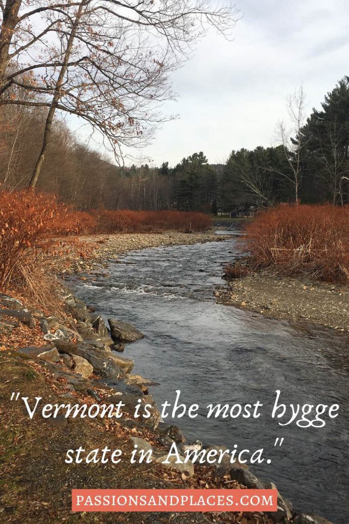Narrow river lined with red bushes, behind the quote, "Vermont is the most higgle state in America."