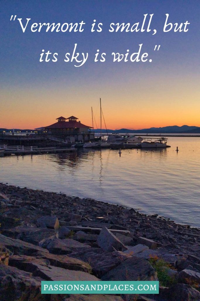 Building and boats on the water at sunset, behind the quote, "Vermont is small, but its sky is wide."
