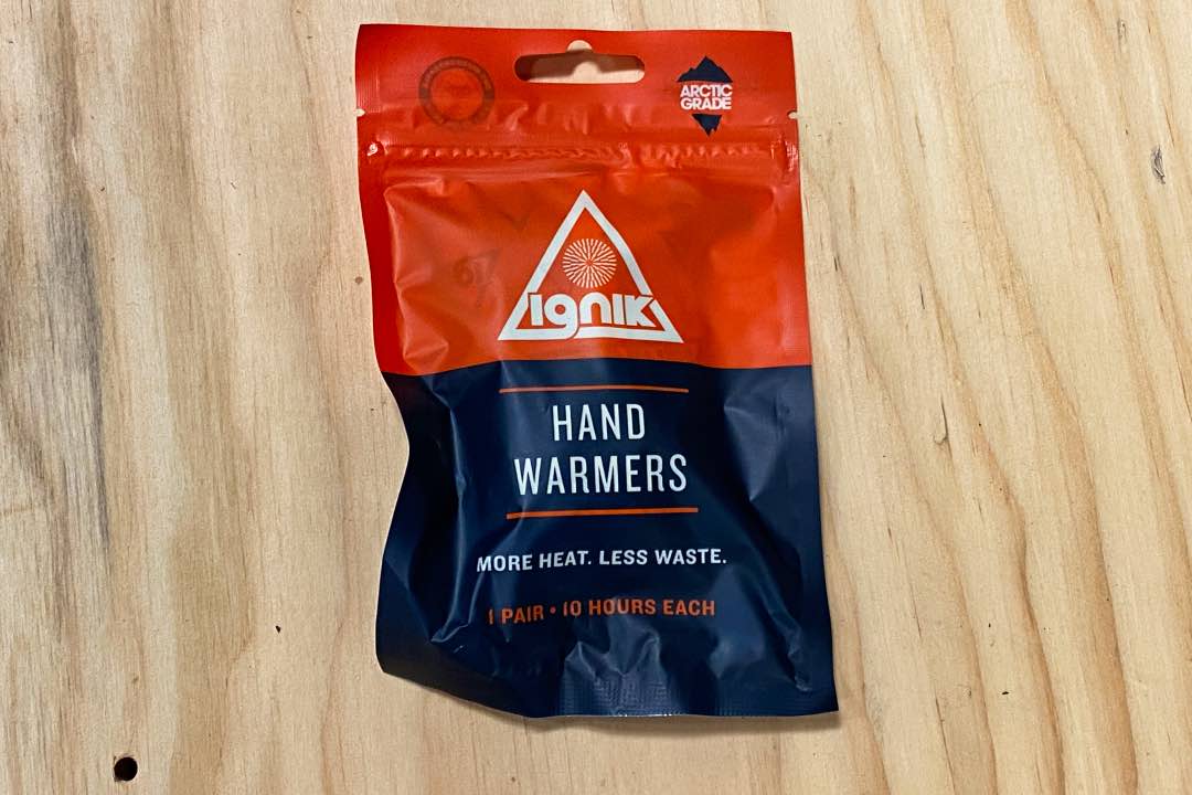 Resealable pouch labeled "Arctic Grade Ignik Hand Warmers," "More heat. Less waste," and "1 pair 10 hours each."