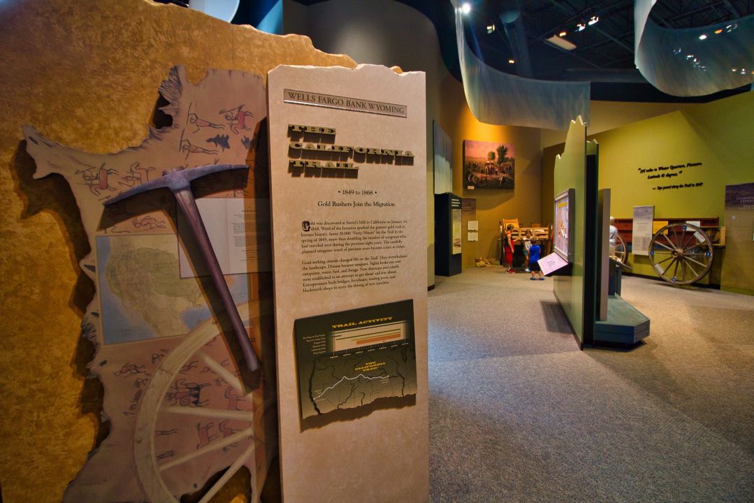 Interpretive signs and replicas of wagons inside a cavernous museum space.